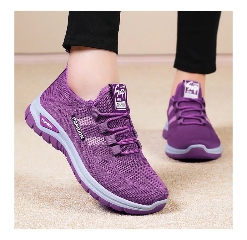 A person models purple mesh athletic shoes with "FOREIGN" detail and thick gray soles.
