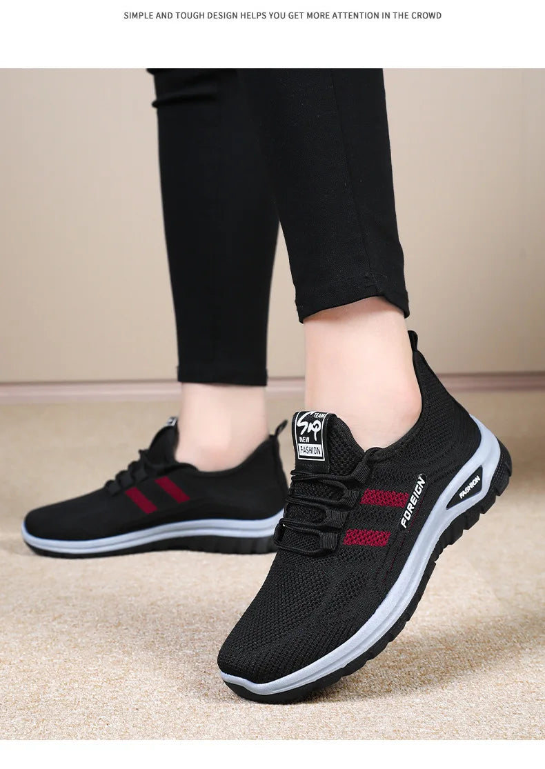 Person models black casual walking shoes with red stripes and a white sole.
