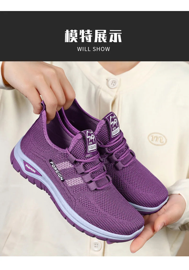 A person holds up a pair of purple mesh running shoes with the word "FOREIGN" displayed on the side.
