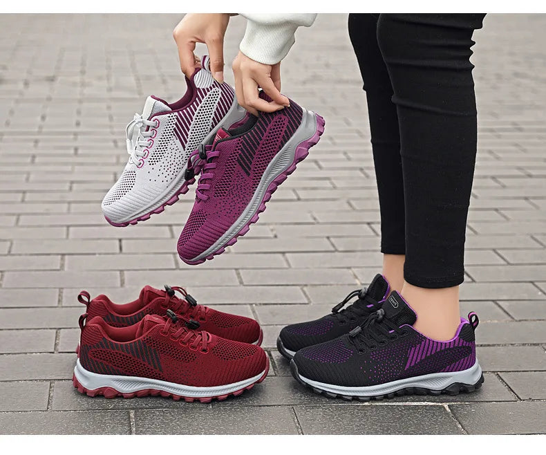 A person showcases a variety of colorful mesh running shoes for sale.
